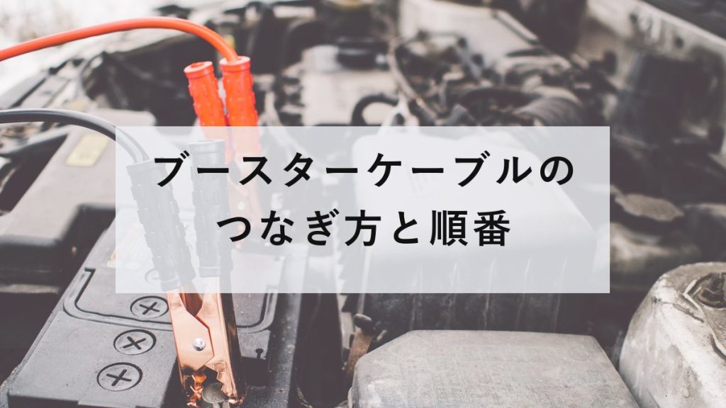 車のバッテリー端子に接続されたブースターケーブル