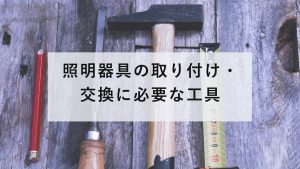電球と圧着工具、ノギスなどの電気工事の道具